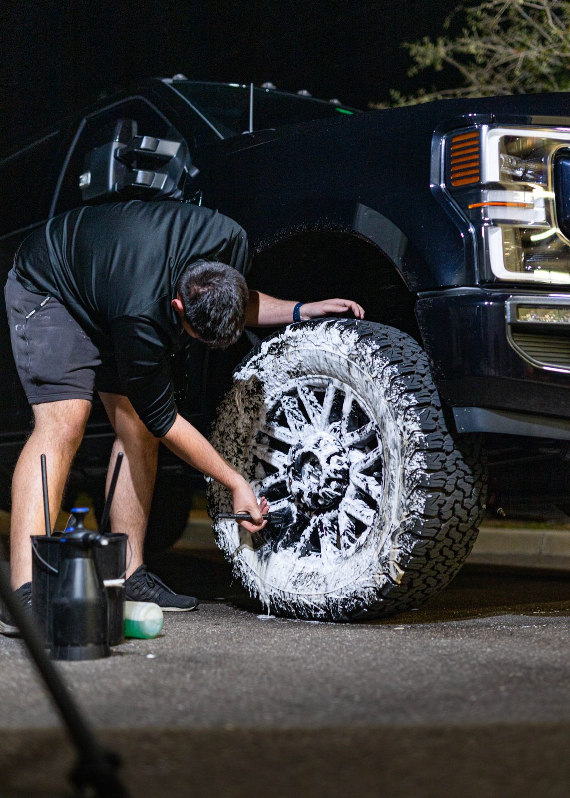 Obsidian detailer polishing a truck wheel at a Towson driveway