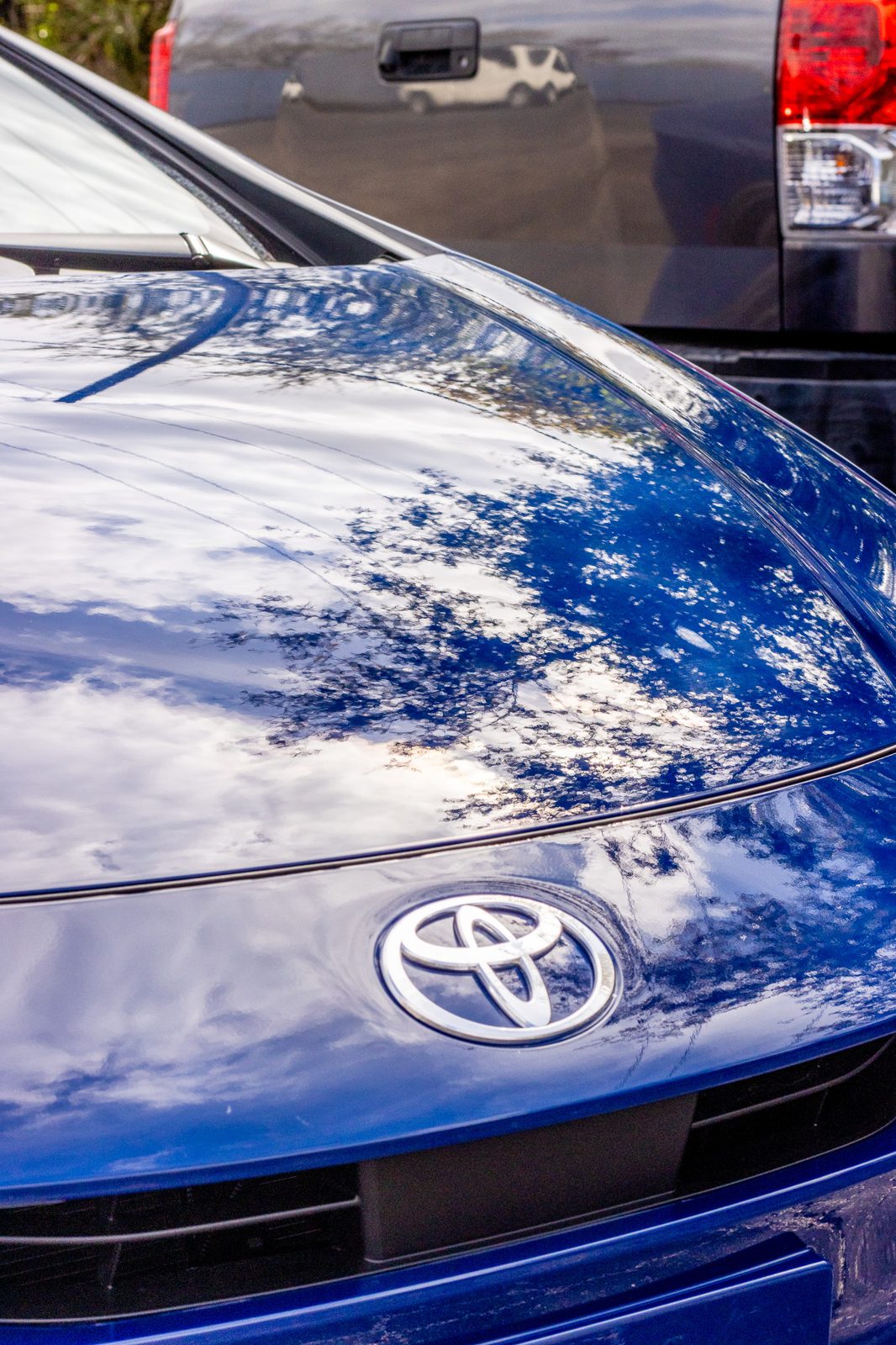 Glossy blue Toyota hood reflecting the sky after a ceramic detail